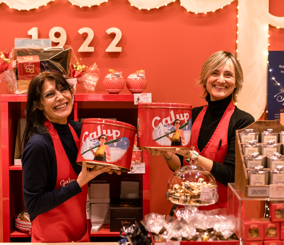 Due commesse sorridenti che della Galup che presentano la confezione del Pandoro Dolcevetta parte di Natale a Candiolo